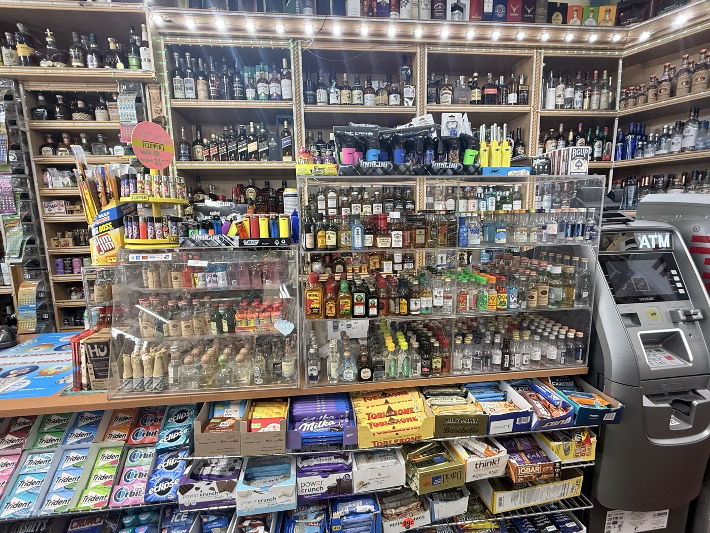 Inside Eddy's Market — behind the counter, mini bottles and top-shelf spirits