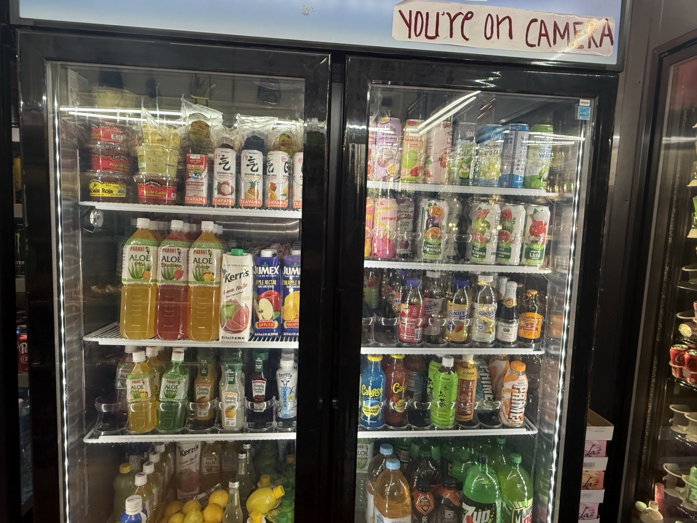 Inside Eddy's Market — the juice fridge with aloe, nectars, and coconut water